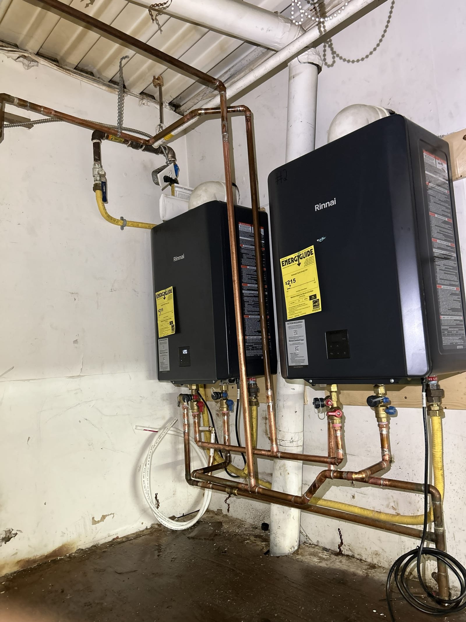 Two wall-mounted Rinnai units connected with copper piping